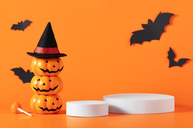 Creative Halloween composition with paper bats podium and orange background Modern Halloween aesthetic