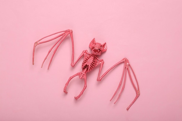 Creative halloween layout Pink bat skeleton on pink background Minimalism Concept art Fresh idea Flat lay Top view