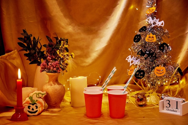 Creative Halloween tree festive party atmosphere Halloween holidays with candles cardboard cups and homemade cookies and calendar Copy space