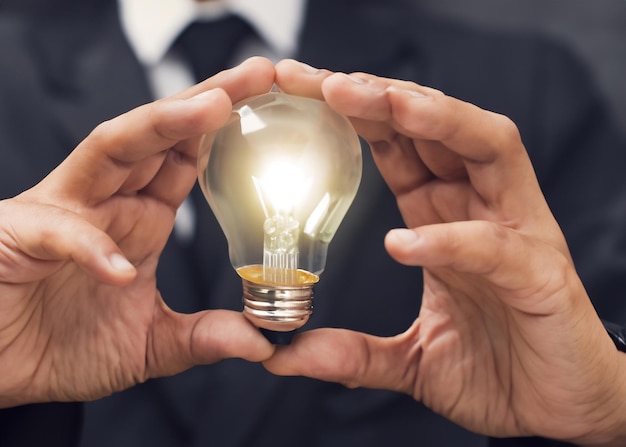 Creative Hand Holding Light Bulb Symbolizing Innovation and Energy for Business and Technology Concepts