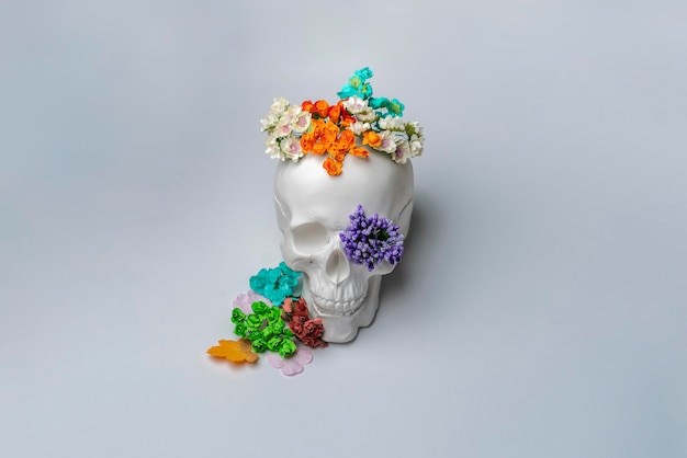 A creative idea of a white skull with flowers around pretty smiling halloween concept