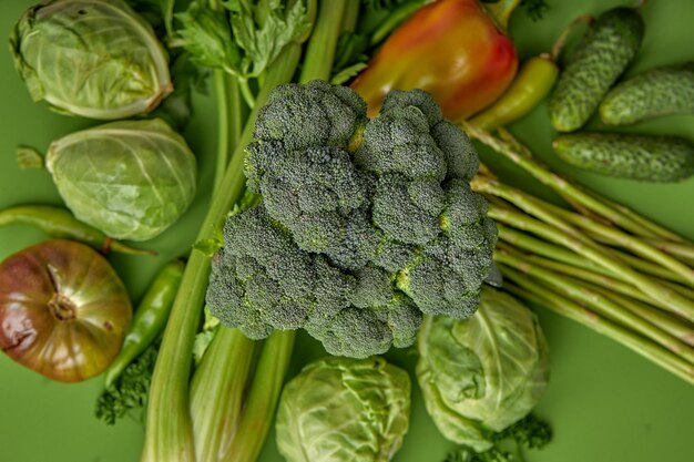 Creative image of broccoli asparagus cabbage greens greenery isolated on green