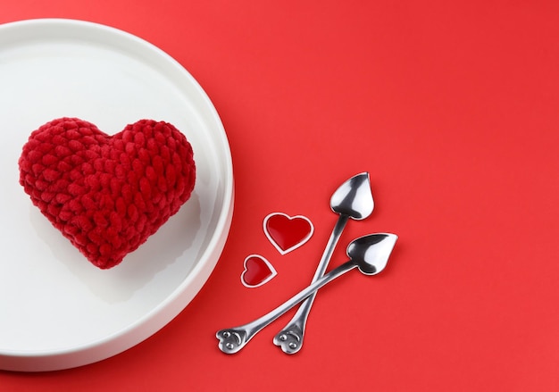 Creative image of valentine hearts served on plate with heart shaped spoons and hearts nearby.