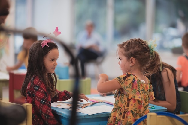 Creative kids sitting in a preschool institution draw and have fun while they get an education