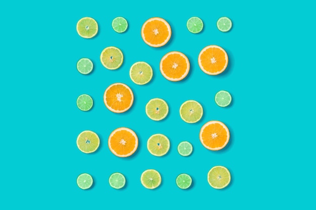 Creative layout made of colorful tropical fruits isolated on blue background Minimal summer concept Citrus fruit pattern Pop art flat lay top view Orange Lime Lemon slices background