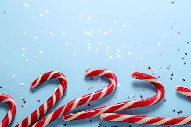 Creative layout made of lollipop cane and sparkling stars Christmas holiday background minimal s concept