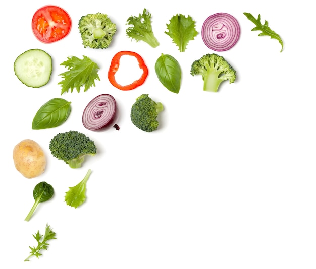 Creative layout made of tomato slice onion cucumber basil leaves Flat lay top view Food concept Vegetables isolated on white background Food ingredient pattern with copy space