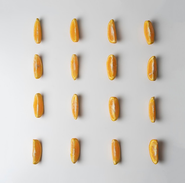 A creative layout of orange fruit slices on white surface