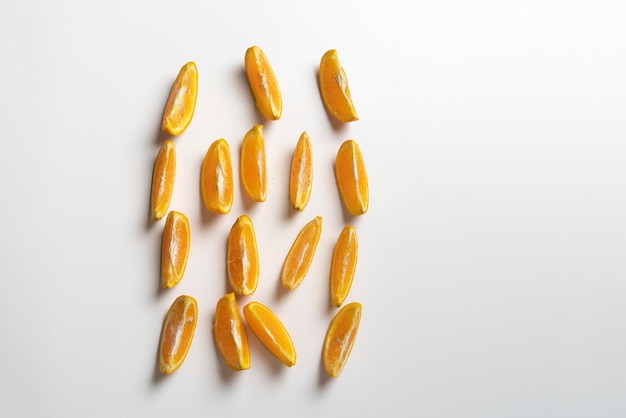 A creative layout of orange fruit slices on white surface