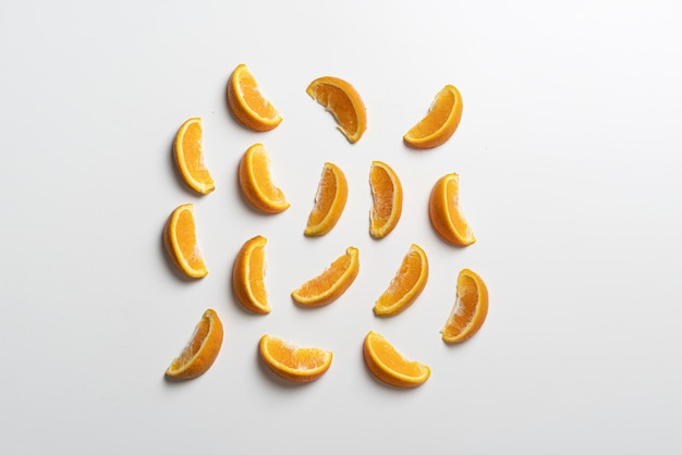 A creative layout of orange fruit slices on white surface