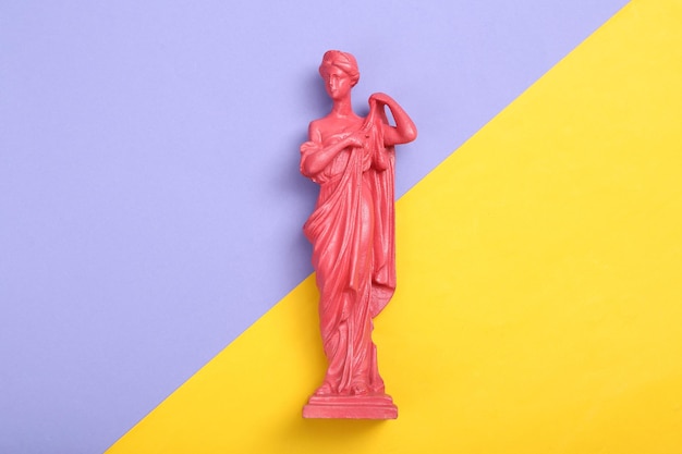 Creative layout Pink Antique greek goddess statue on purple yellow background Flat lay Top view