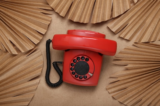 Creative layout Retro rotary phone and palm leaves on beige background Flat lay