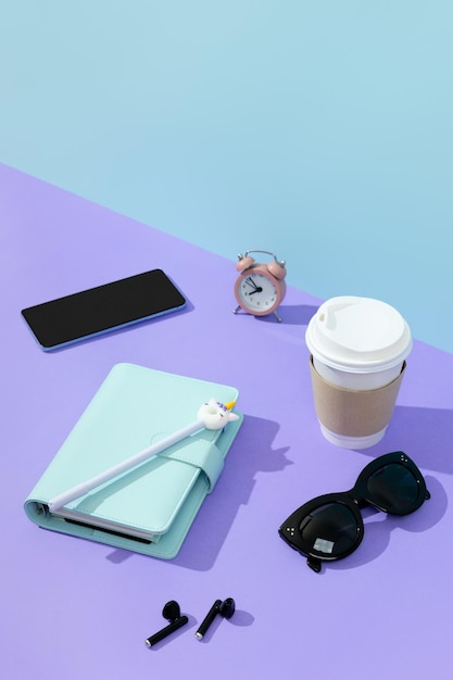 Creative layout with stationery coffee cup and headphones on purple table