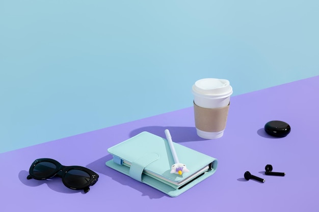 Creative layout with stationery coffee cup and headphones on purple table