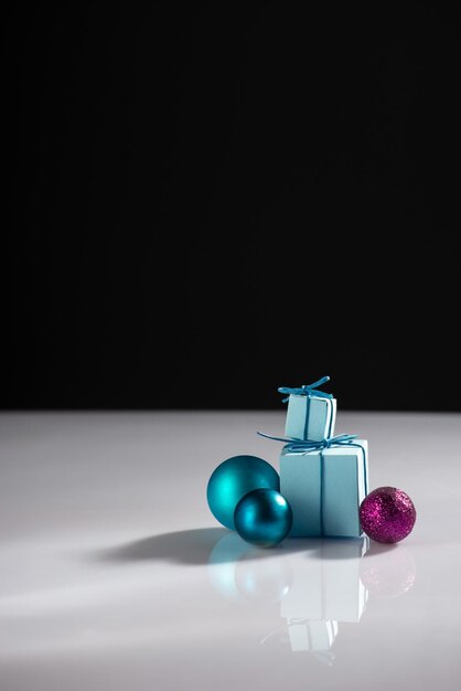 Creative minimalistic new year still life with gifts and christmas tree decorations