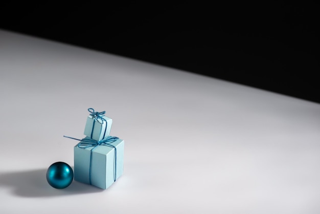 Creative minimalistic new year still life with gifts and christmas tree decorations