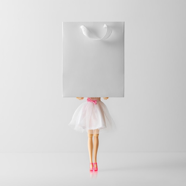 Creative mockup of a sale on a white background. Young girl holding a gift bag. Shopping concept.