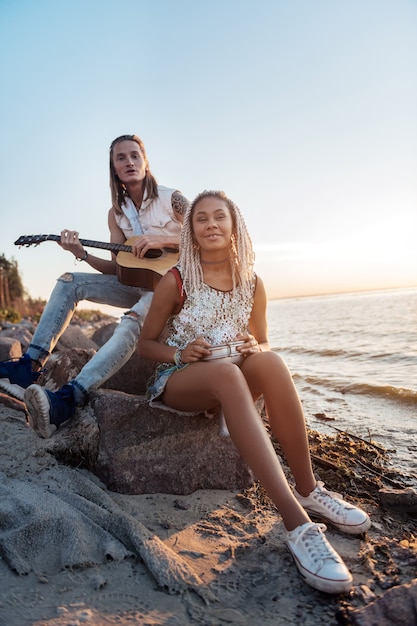 Creative musicians. Couple of creative inspired musicians playing their favorite song near the seaside