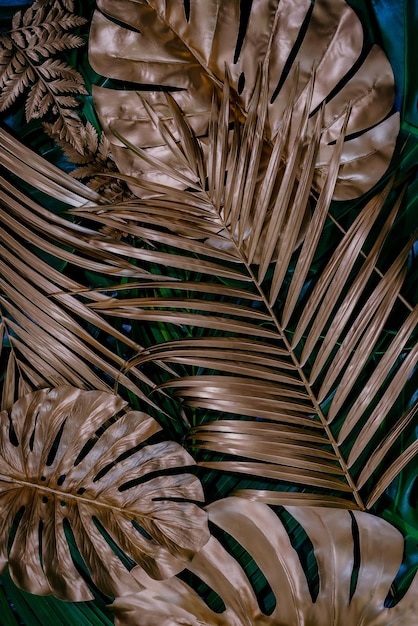 Creative nature background Gold and green tropical Monstera and palm leaves Minimal summer abstrac