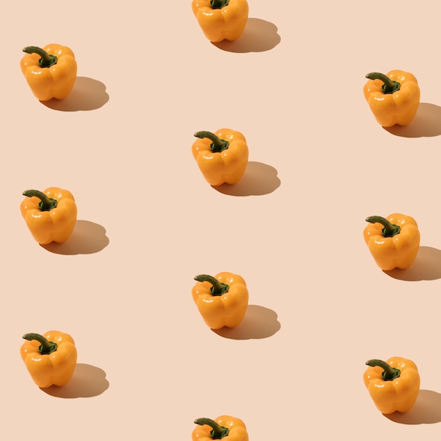 Creative pattern made of fresh yellow organic bell peppers on pastel backgroundMinimal food concept