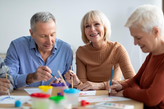 Creative senior people enjoying painting class at sanatorium