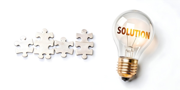 Photo creative solution concept light bulb and puzzle pieces in flat vector design for smart business sol