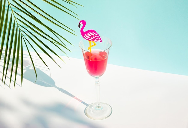 Creative summer composition with glass of juice flamingo and palm leaf Minimal summer drink concept