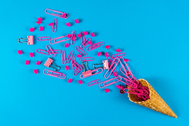 Photo creative summer layout made of ice cream cones, pink bulldog clips, paper clips, push pins