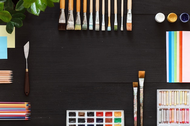 Creative supplies on black wood desk