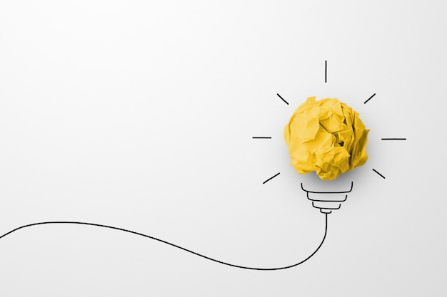 Creative thinking ideas and innovation concept Paper scrap ball yellow colour with light bulb symbol on white background