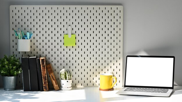 Photo creative workplace with computer laptop potted plant coffee cup and stationery