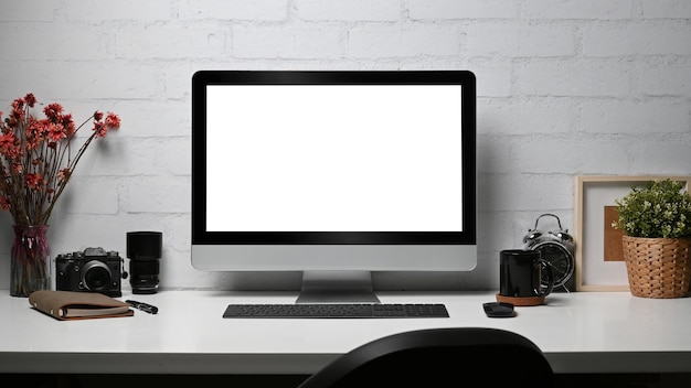 Creative workplace with computer pc camera notebook and houseplant on wooden desk Empty display for your advertise text