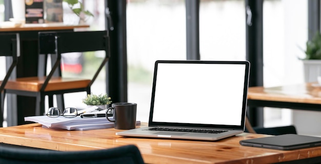 Creative workspace blank screen laptop computer on wooden table mockup blank screen laptop