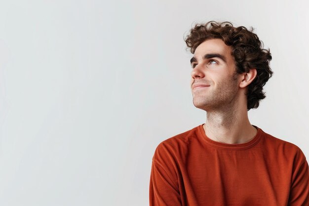 Creative young man thinking and smiling looking at upper left corner thoughtful standing over white