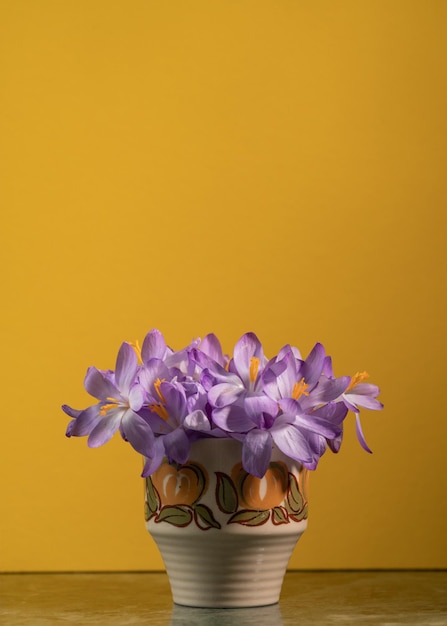 Creativity bouquet with spring crocus flowers in vase on yellow background Spring minimal concept