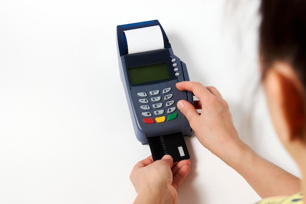 Credit card payment, buy and sell service. Woman hand with credit card and payment terminal on white background, close-up