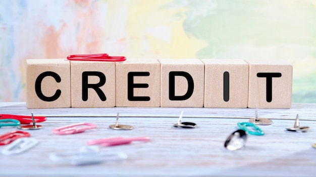 CREDIT text written on wooden cubes on a light colored background