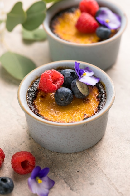 Creme brulee. French vanilla cream dessert with caramelised sugar and berries, selective focus.