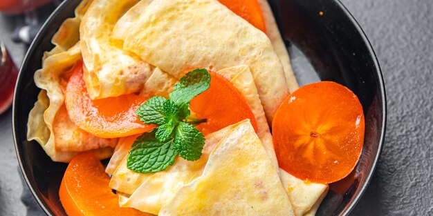 Crepe persimmon thin pancakes fruit breakfast sweet dessert healthy meal food snack on the table