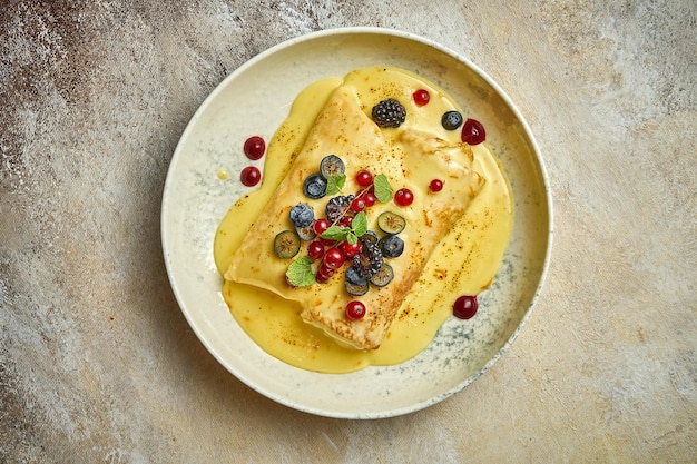 Crepes or bliny with custard berries and cottage cheese Closeup selective focus Ukrainian cuisine