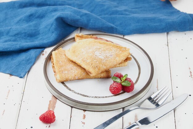 Crepes stuffed on plate thin pancakes blini white wooden table