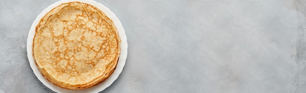 Crepes, thin pancakes on gray plate. Marble table. Copy space.  Top view