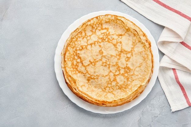 Crepes, thin pancakes on gray plate. Marble table