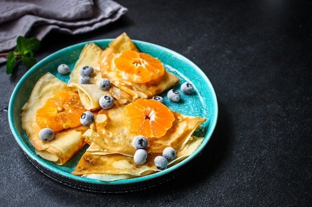 crepes with citrus, jam and berries