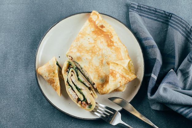 Crepes with stuffed cream cheese spinach turkey on plate Cuisine meal food concept Top view