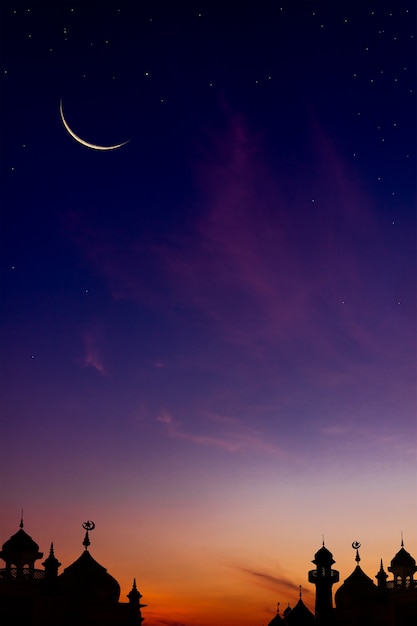 Crescent moon on twilight sky on sundown with sunlight over dome mosques