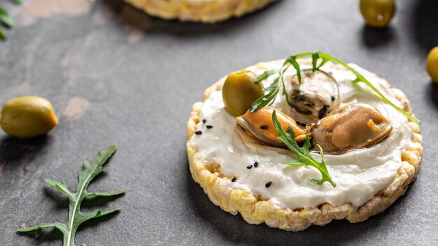 Crisp bread healthy snack Mussels bruschetta toast with soft cheese and arugula Long banner format top view