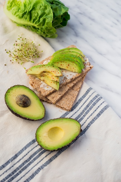 Crisp bread with sliced avocado on table