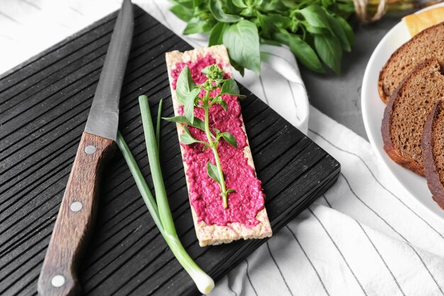 Crispbread with delicious beet hummus on wooden board