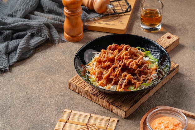 Crispy beef fillet pieces with mayonnaise plating on a black plate